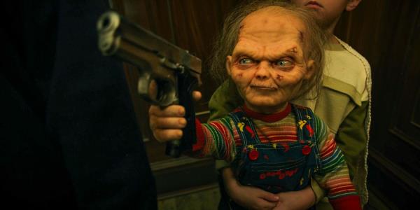 Chucky threatening with a gun while Henry holds him Chucky season 3 part 2 ep 6